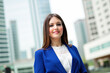 © Minerva Studio - Businesswoman smiling in modern city business district