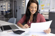 © fizkes - Enjoying finance growth. Happy smiling millennial woman project manager bookkeeper read statistic papers at workplace satisfied with successful financial forecast positive cash flow good sales results