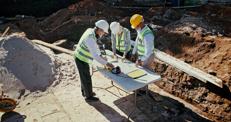 Poster - Above, people and team on construction site for planning, check blueprint and engineering collaboration. Architect group, building layout and outdoor in meeting for brainstorming, compliance and PPE