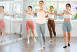 © JackF - Slender young female attendee of dancing classes training ballet positions together with other group members