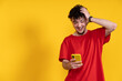 © Ceballos - Excited young man reading good news on smartphone on yellow background