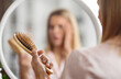 © Prostock-studio - Hairloss Concept. Shocked Blonde Woman Holding Comb Full Of Fallen Hair After Brushing, Closeup Shot Of Middle Aged Lady With Brush In Hand Standing Near Mirror, Suffering Alopecia Or Health Problems
