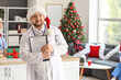 © Pixel-Shot - Male doctor in Santa hat with clipboard at hospital on Christmas eve