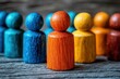 © Worrapol - Colorful Wooden Figurines in Row Illustrating Unity, Diversity, and Community Engagement on Rustic Wooden Background