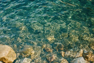 Poster - Clear Lake Water Rippling Over Rocks from Above on a Sunny Day in Nature's Serenity and Tranquility for Backgrounds