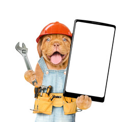 Poster - Happy Mastiff puppy with adjustable wrench wearing hardhat and overalls with tool belt showing big smartphone with white blank screen in it paw. Isolated on white background. Empty space for text