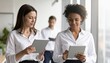 © Bright Bites - Modern tech office interior with diverse professionals using tablets