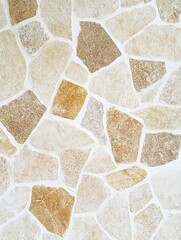 Poster - Stone wall texture background in beige and brown tones close up full frame shot for design and decoration neutral color palette