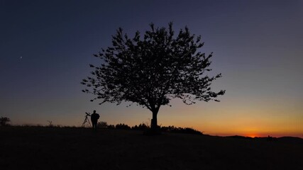 Wall Mural - amateur astronomer looking at the evening skies, observing planets, stars, moon and other celestial 