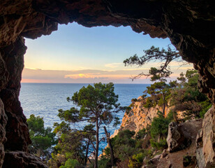 Wall Mural - stunning view through rocky cave, showcasing serene ocean and lush greenery. sunlight casts warm glow over landscape, creating peaceful and inviting atmosphere