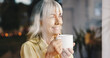© peopleimages.com - Coffee, thinking and window with senior woman in retirement home for memories or nostalgia. Relax, smile and wellness with happy mature person drinking caffeine beverage in apartment for weekend