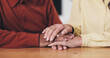 © peopleimages.com - Home, table and old couple with holding hands for support, empathy and comfort to partner with grief. Closeup, senior people and love with sympathy for loss, compassion and kindness with commitment