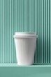 © DriftPixels - White paper coffee cup with lid on mint green platform against corrugated wall studio shot product photography