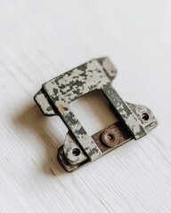 Poster - Macro shot of a weathered metal bracket on a white wooden surface displaying signs of rust and wear and tear