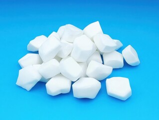 Poster - Pile of White Rock Candy Pieces on Blue Background Studio Shot Overhead Close Up Sweet Treat Confectionery Dessert