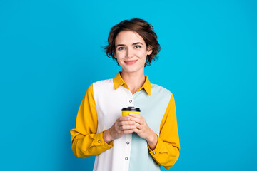Poster - Photo of positive girl hold paper cup with aromatic cappuccino for start working day isolated blue color background