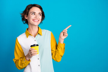 Poster - Photo of positive attractive girl demonstrate empty space with takeout mocha latte isolated blue color background
