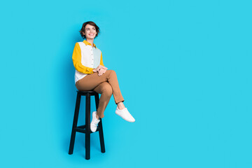 Poster - Photo of executive girl sit cafetria chair look on empty space isolated blue color background