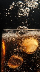 Poster - Refreshing cola drink with ice cubes and bubbles in glass close up studio shot on black background for summer refreshment