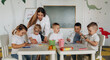 © standret - Holding markers, learning to draw. Children in kindergarten with their teacher