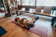 © qunica.com - A person stretches during a yoga session at home, lying on a mat surrounded by natural light and comfortable furnishings, showcasing personal fitness, relaxation, and mindfulness.