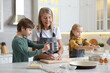 © New Africa - Grandmother and her grandchildren making dough at white marble table in kitchen