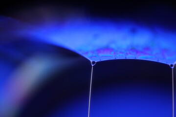 Poster - Deep blue liquid surface on black background, oil stains movement, bright chemistry, surreal background, blue sky colour