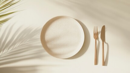 Aufkleber - Empty plate, cutlery, and palm leaf shadow on beige background.