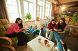© master1305 - Group of young people sit with books and tea in loft living room enjoying literature and warm atmosphere. Concept of education, leisure, literature, lifestyle, bonding, community, social interaction
