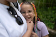 © PeterPike - Mother hugging her smiling daughter in glasses standing in summer park. Concept of children's emotions and joy
