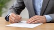 © Dzikrul Husnani - Person Signing Document with Pen on Wooden Table