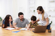 © New Africa - Parents helping their kids with homework at wooden table indoors