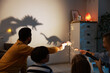 © New Africa - Parents performing shadow play with toy dinosaurs to their kids at home