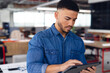 © Wavebreak Media - Man leaning over desk in modern open-plan office interacting with tablet, copy space