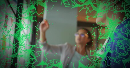 Poster - Business team pointing at wall display in modern office, featuring green network lines