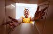 © Prostock-studio - Delivery Concept. Excited african woman unpacking, opening carton box and trying to get something, view from the inside