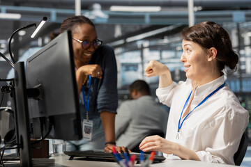 Poster - Happy server hub team leader does fist bump with worker after completing operations. Cheerful manager congratulating engineer in data center after checking report showing stable performance indicators