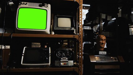 Wall Mural - vintage analog tv set turning on green screen display, surrounded by old technology in an antique st