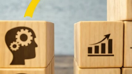 Poster - Wooden blocks showing heads with gears and lightbulbs with a yellow arrow pointing towards them