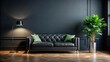 © Buakung - A spacious dark room with a black sofa and a vibrant green plant in the corner