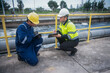 © akarapon - A professional engineer and technician are working together to seriously check the water quality in a water treatment pond.