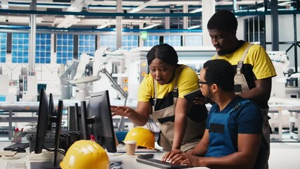 Poster - photovoltaics facility employees evaluating performance of robot arms placing solar panels on assemb