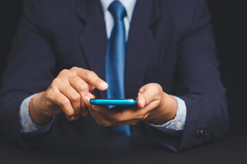 Wall Mural - businessman in suit using smartphone, digital communication and productivity concept.