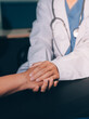 © ARMMY PICCA - female doctor or woman medical staff holding hand, working hand in hand, giving encouragement to patient or relative of patient; concept of woman health care worker, doctor, therapist, medical worker