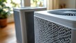 © HERMAWAN - Two modern air purifiers, close-up view.  Grey/white units with patterned grills
