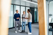 © Westend61 - Business meeting in a modern office with three people discussing using a tablet