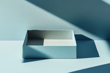 Aufkleber - Empty light-blue box on a pale blue surface, sunlit