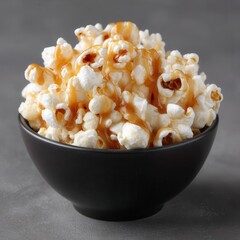 Poster - A black bowl filled with crunchy popcorn, drizzled with a decadent caramel sauce. A classic movie snack, elevated with delicious flavor.