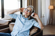 © Maria Vitkovska - Happy senior woman listening music with wireless headphones at home