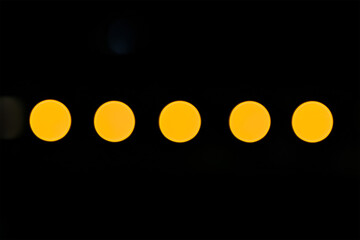 Poster - A row of five evenly spaced vibrant yellow bokeh circles contrasted against a deep black background creating a visually appealing artistic composition.